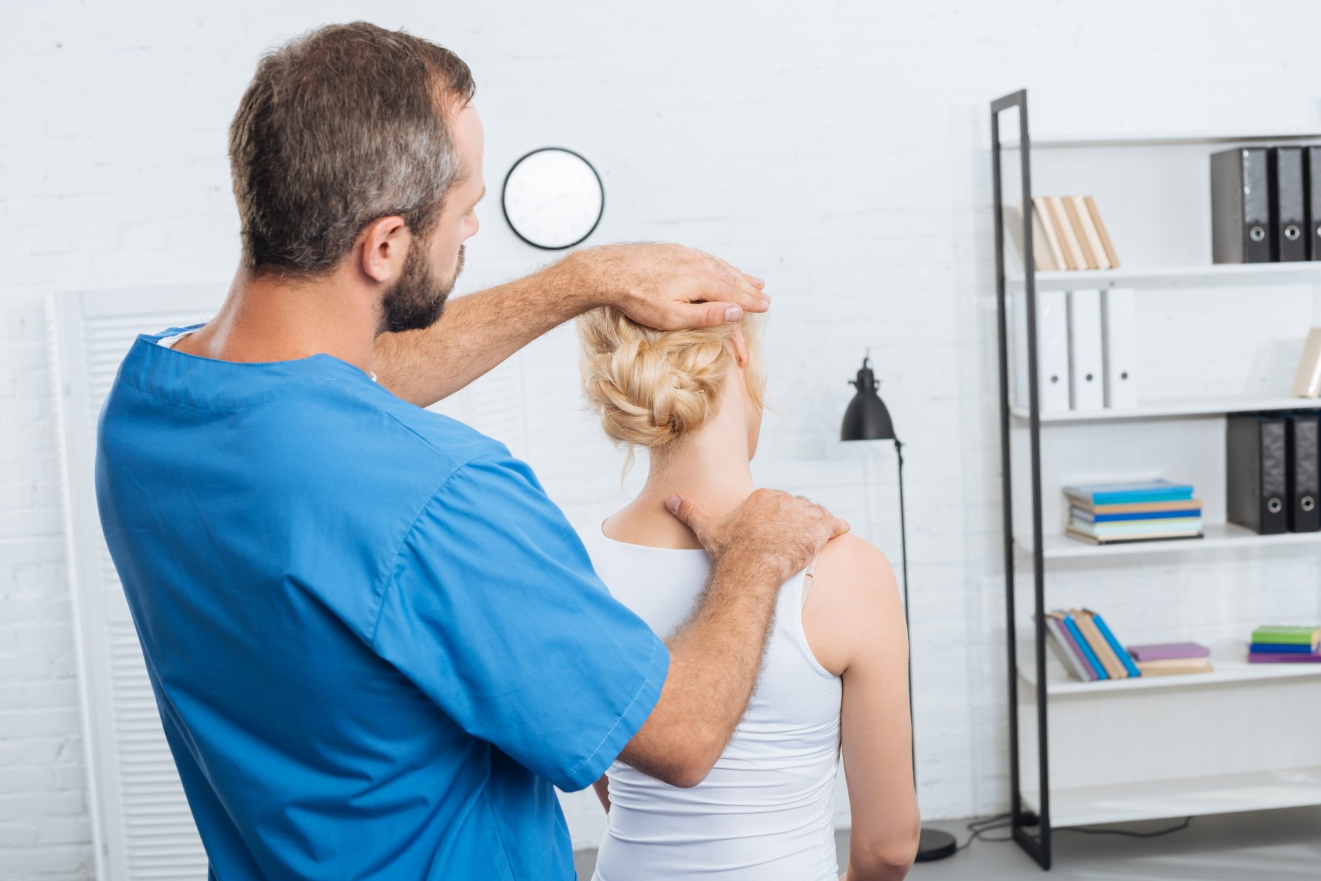 chiropractor stretching neck of woman